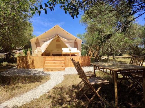 a tent with a table and chairs in front of it at Tranquilo Glamping in Hozanejos