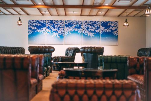 a waiting room with chairs and paintings on the wall at Iwaiyado Jyuan Nikko Kawaji onsen in Nikko