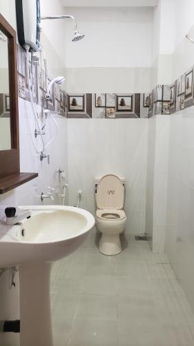 a white bathroom with a sink and a toilet at Vaas Place in Hikkaduwa