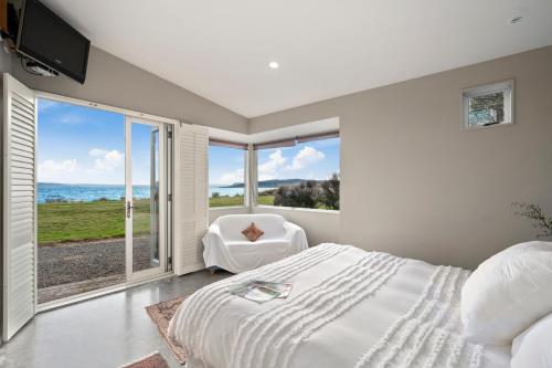 a bedroom with a bed and a view of the ocean at Five Mile Bliss - Lake Taupo Holiday Home in Waitahanui