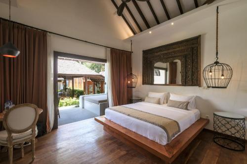 a bedroom with a large bed and a mirror at Villa Aram Canggu in Canggu