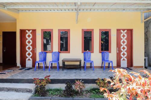 a group of blue chairs sitting in front of a building at Omah Rohadi Syariah by Ndalem Beong in Borobudur