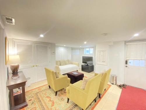 a living room with a bed and chairs and a table at Renovated English Basement 2bdrm Home near METRO in Washington, D.C.