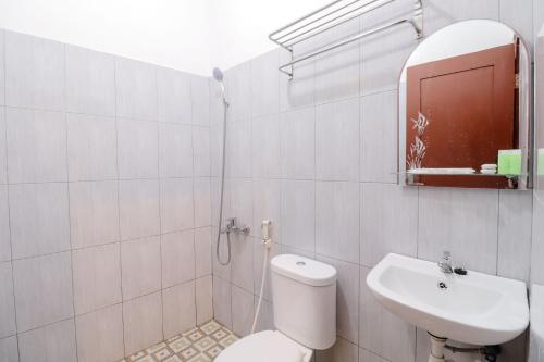 a white bathroom with a toilet and a sink at Omah Rohadi Syariah by Ndalem Beong in Borobudur