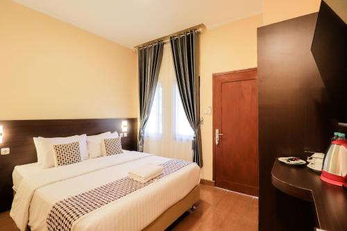 a bedroom with a large bed and a window at Omah Rohadi Syariah by Ndalem Beong in Borobudur