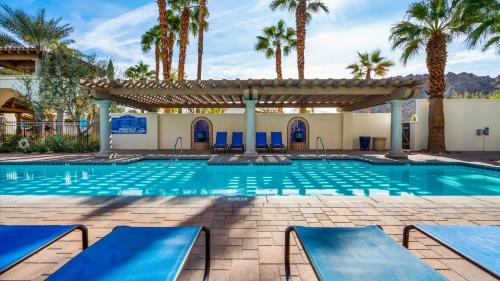 a swimming pool with palm trees and a pergola at LV025 Airy Upstairs Studio with Mountain Views in La Quinta
