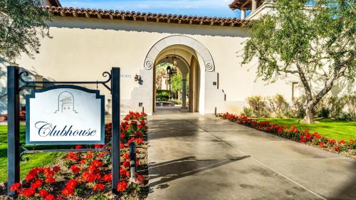 a sign in front of a building with red flowers at LV025 Airy Upstairs Studio with Mountain Views in La Quinta