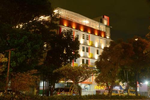a large white building with lights on it at night at Front One Hotel Pasir Koja Bandung in Bandung