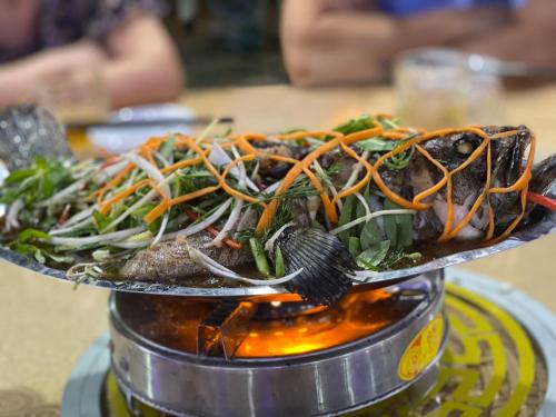un plato de comida sentado sobre una mesa en Khách sạn An Phú Cửa Lò en Cửa Lò