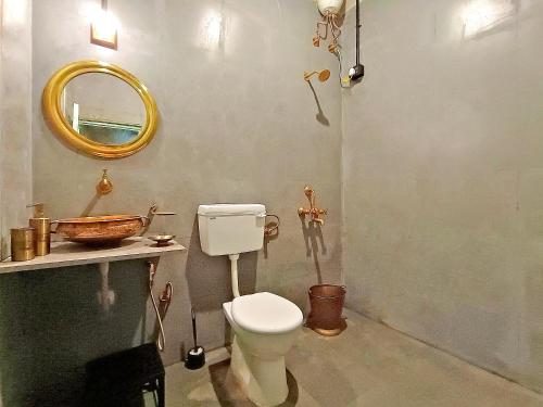 a bathroom with a toilet and a mirror at Sulu's Nature Farm in Lonavala