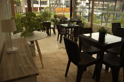 uma sala de jantar com mesas, cadeiras e janelas em Casablanca Lima em Lima