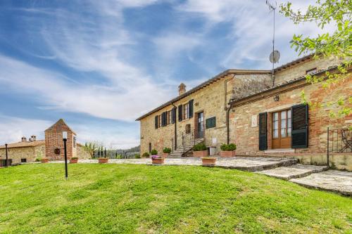 un grande edificio in mattoni con un prato davanti di Santarcangelo Apartments - Happy Rentals ad Asciano