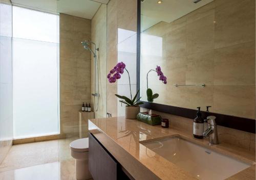 La salle de bains est pourvue d'un lavabo et de toilettes. dans l'établissement Ocean View 3 Bedrooms Brand New Stylish Villa With Private Pool, Gazebo, & Garden, Bali, à Ketewel