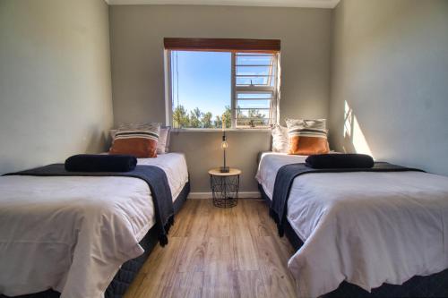 2 camas en una habitación con ventana en Magnificent Villa Load-Shedding Free! en Ciudad del Cabo