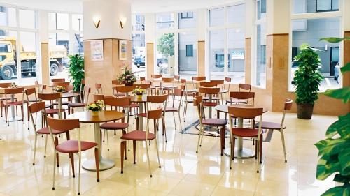 een restaurant met tafels, stoelen en ramen bij Toyoko Inn Iwaki Ekimae in Iwaki