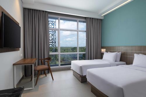 Postel nebo postele na pokoji v ubytování Hotel Santika Gunungkidul