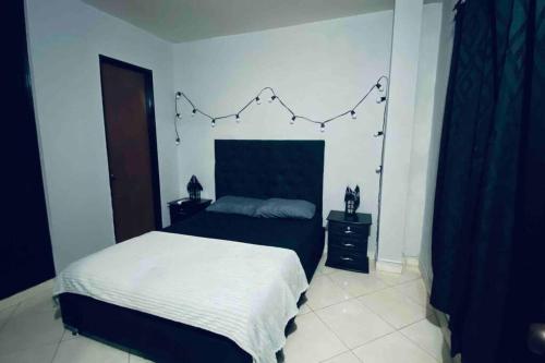 a bedroom with a bed with a string of lights on the wall at Apartamento confortable y cálido in Itagüí