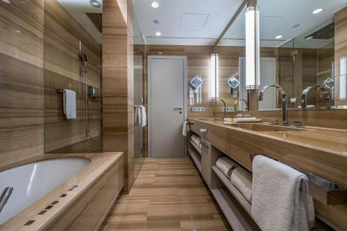 a bathroom with two sinks and a bath tub at Maritim Hotel Ingolstadt in Ingolstadt