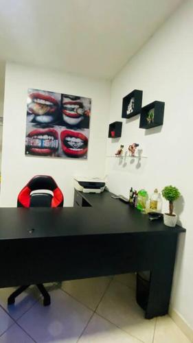 a black desk with a red chair in a room at Apartamento confortable y cálido in Itagüí