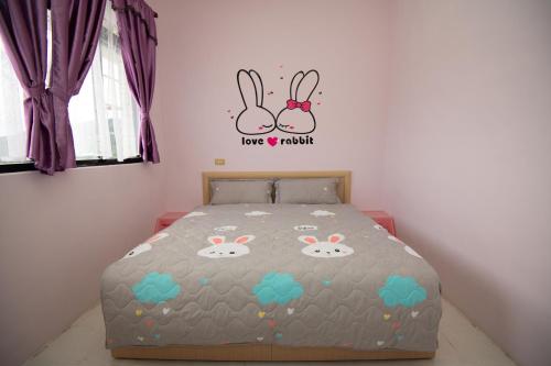 a bedroom with a bed with bunnies on it at Green Close House Homestay in Yuanshan