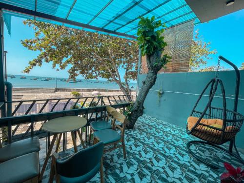 a balcony with a swing and a table and chairs at Lê Huỳnh Guest House Family in Ke Ga