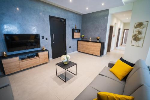 a living room with a couch and a flat screen tv at Red Rose in Marsalforn