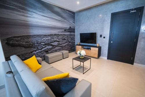 a living room with a couch and a television at Red Rose in Marsalforn