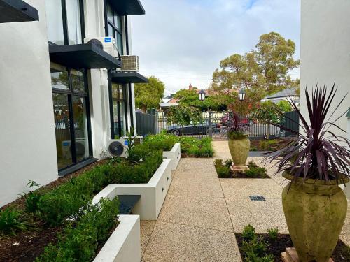a walkway in front of a building with potted plants at The Osmond Motel & Apartments in Adelaide