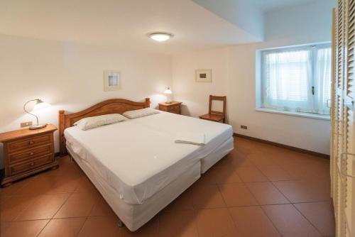 a bedroom with a large white bed and a window at Ferienwohnung in Finale Ligure mit Großem Garten in Finale Ligure