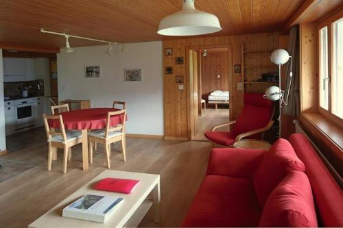 a living room with a red couch and a table at Chalet Varga in Hasliberg