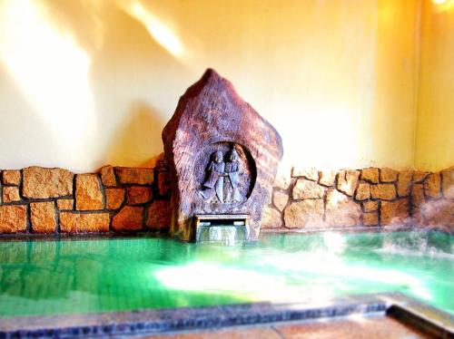 a swimming pool with a statue of a woman at Central Hotel 中央ホテル in Chikuma