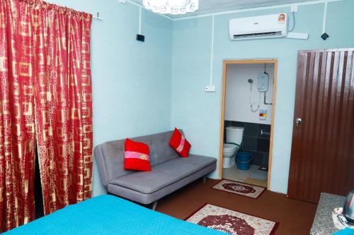 soggiorno con divano e cuscini rossi di Villa Uda @ SIBLINGS Cottage a Setiu