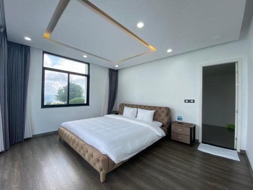 a bedroom with a large bed and a window at Chuỗi Villa FLC (4 Ngủ, 5 Ngủ, 6 Ngủ) in Ha Long