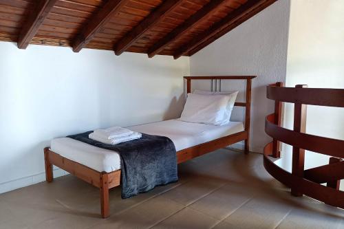 una piccola camera da letto con un letto e una sedia di Villa Totti a Ierissós