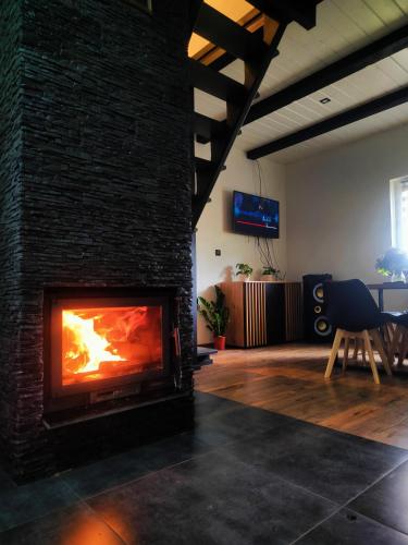a fireplace in a living room with a brick wall at Chatka pod KLONAMI - Roztocze in Józefów