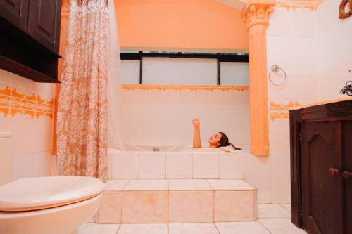 una mujer acostada en una bañera en un baño en Hotel Boutique Casa José, en Cobán