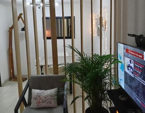 a living room with a chair and a tv and stairs at Departamento Cerca del Aeropuerto/ Buena Ubicación in Mexico City