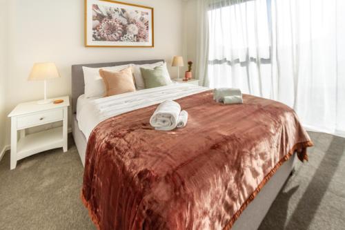 - une chambre avec un grand lit et 2 serviettes dans l'établissement Cozy 3 bedroom near Hagley Park w/Garage, à Christchurch