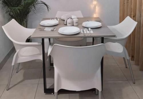a dining room table with white chairs and a table and chairsktop at Departamento Cerca del Aeropuerto/ Buena Ubicación in Mexico City