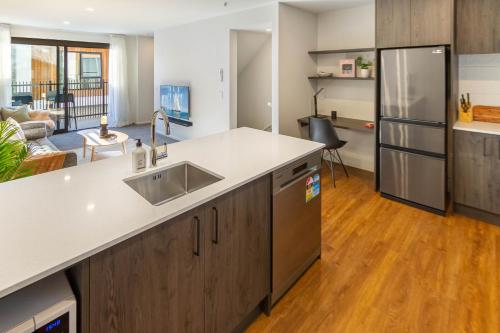 an open kitchen with a sink and a refrigerator at Cozy 3 bedroom near Hagley Park w/Garage in Christchurch