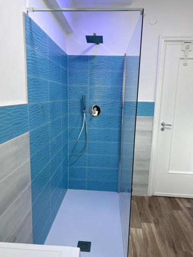 ein Bad mit einer Dusche und blauen Fliesen in der Unterkunft Blue Sea in Arma di Taggia