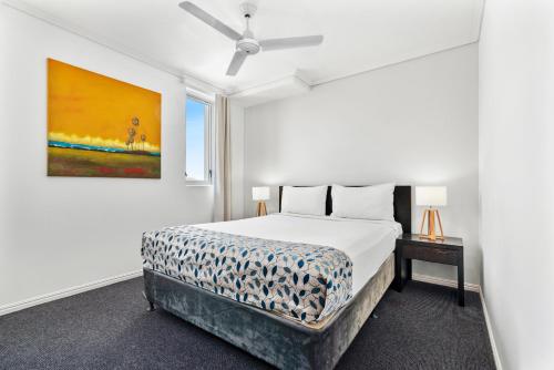 1 dormitorio con 1 cama y una pintura en la pared en Cairns Central Plaza Apartment Hotel Official en Cairns