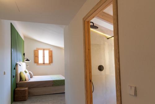 a bedroom with a bed and a walk in shower at Agroturisme Subies in Selva