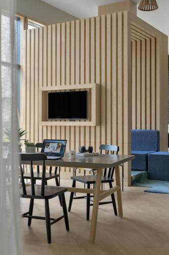 a dining room with a table with chairs and a laptop at Ginger Chandigarh, Zirakpur in Zirakpur