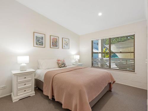 a white bedroom with a bed and a window at Montville Attic in Montville