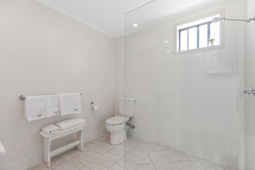 a white bathroom with a toilet and a window at Montville Attic in Montville