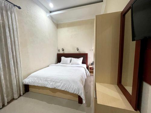 una camera con letto e TV a schermo piatto di OYO 92571 Zulyan Homestay Syariah a Bukittinggi