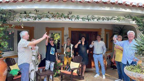 a group of people standing in front of a house at Villa Lagos Algarve for families & friends, 6 bedrooms, 7 bathrooms, pool, BBQ, central heating in Pedra Alçada