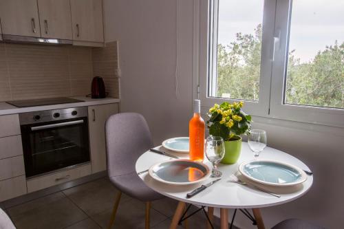 a white table with two plates and a vase of flowers at heaven suite elafonisi in Elafonisi