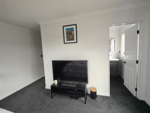a living room with a large flat screen tv at Quality Stay Private Guest Room in Auckland in Auckland